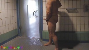 Guy plays with his big cock and tight butt hole in a public shower room