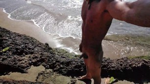 Daring young man enjoys naked in public on the beach